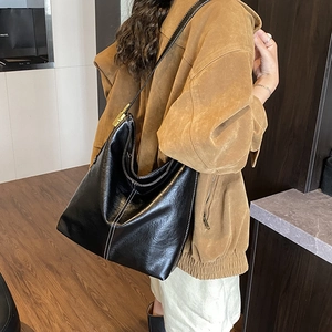 Détail du grand sac hobo noir avec coutures blanches contrastées et boucles dorées