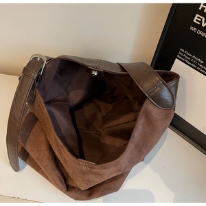 Detail view of large brown suede bucket bag interior with secure magnetic buckle closure