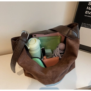 Detail showing high-capacity interior of brown suede bucket bag with daily essentials