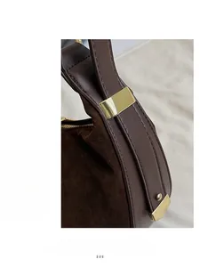 Detail of vintage brown tote showing mixed leather texture and golden metal buckle