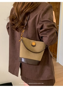 Detail of vintage suede bucket bag with olive green finish and brown leather base