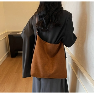 Detail of a large brown suede tote bag featuring high-quality texture and vertical stitching