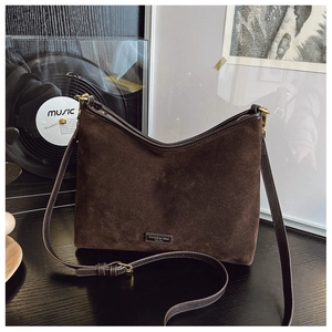 Dettaglio della borsa tote in pelle scamosciata marrone scuro con logo in metallo