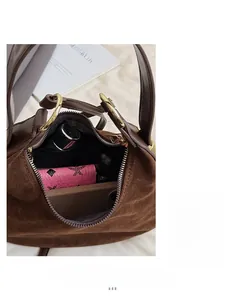 Internal view of dark brown suede handbag showing spacious storage for daily essentials