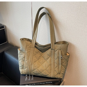 Vue détaillée du sac cabas en nylon matelassé vert olive avec bretelles et fermetures éclair