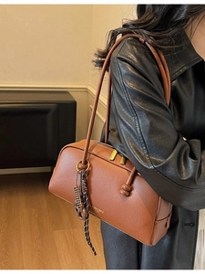 Sac bowling marron en cuir grainé avec détails dorés et bandoulière longue