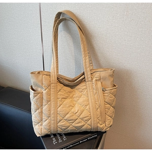 Détail du sac cabas matelassé beige montrant les poches latérales et le tissu en nylon