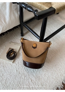 Detail view of retro suede bucket bag with dual-texture splicing and brass hardware