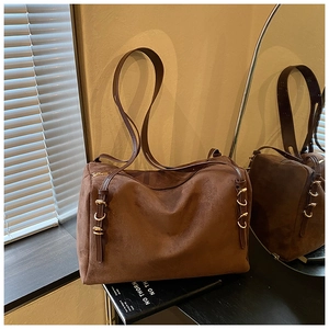 Detailed close-up of brown suede oversized Boston bag showing side adjustable metal buckles