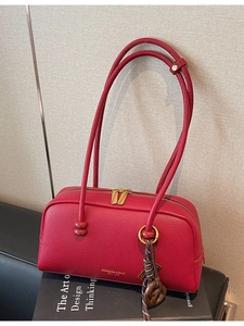Sac bowling en cuir grainé rouge avec fermeture dorée et design de forme oreiller