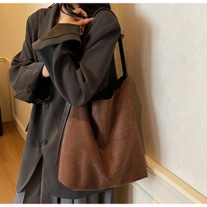 Detail of vintage brown suede tote bag showing large capacity and soft matte texture on model