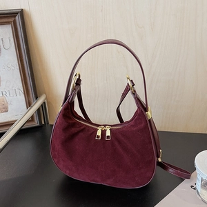 Close-up of burgundy suede hobo bag with luxury gold double zippers and hardware