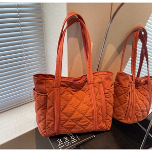Gros plan sur le sac fourre-tout matelassé orange vif avec surpiqûres en losanges élégantes