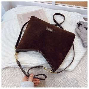 Dettaglio della borsa tote in pelle scamosciata marrone scuro con finiture dorate su maglia