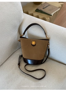 Close-up of vintage bucket bag with khaki suede and dark brown leather patchwork