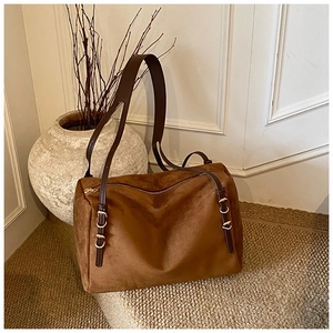 Detailed view of brown suede Boston bag with leather straps and gold metal hardware
