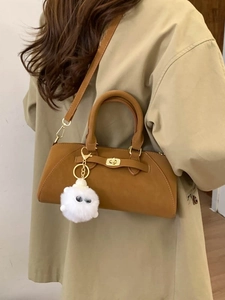 Borsa a conchiglia marrone scamosciata con chiusura dorata e ciondolo in peluche