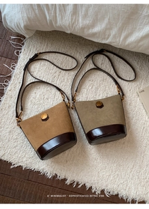 Detail of vintage suede bucket bags in tan and olive with polished leather base