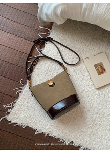Detail of vintage bucket bag with beige suede texture and brown polished leather bottom