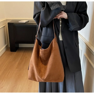 Detail of caramel suede tote bag featuring a spacious interior and adjustable shoulder strap