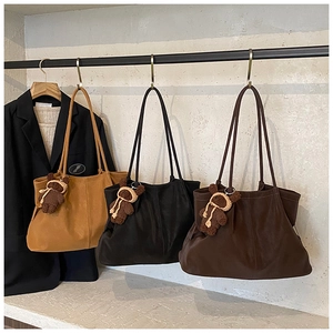 Detailed shot of large tote bags in camel, black, and brown with pleated texture