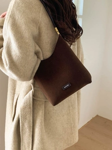 Minimalist dark brown suede hobo bag with thin black straps and NO FILTER text label