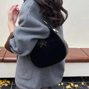 Detailed side view of black hobo shoulder bag featuring suede texture and gold zipper