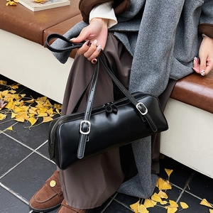 Close-up of black matte leather bowling bag featuring silver buckles and dual zippers