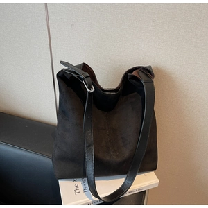 Detail view of black suede hobo bag with adjustable leather strap and silver buckle