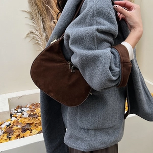Detailed texture of high-quality dark brown suede on a stylish half-moon hobo bag