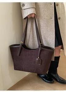 Vue détaillée du sac cabas en daim marron foncé avec charm cœur et boucle dorée