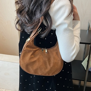 Detail of the adjustable golden buckle and premium brown suede finish on the crescent bag