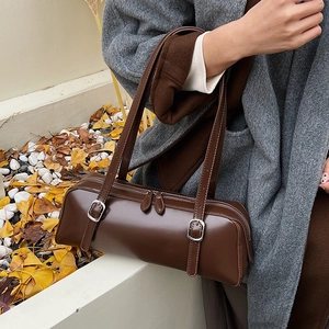 Detail of dark brown leather shoulder bag with silver hardware and double zippers