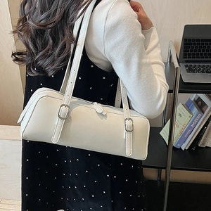 Detail of white leather barrel shoulder bag with adjustable straps and silver buckles