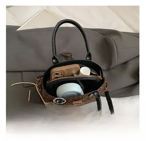Interior view of leopard print shell bag showing storage capacity and black lining