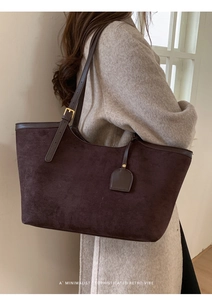 Détail du sac cabas en daim marron vintage avec anses en cuir et boucles dorées