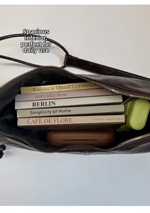 Macro view of spacious interior of dark brown oil wax leather shoulder bag with daily items