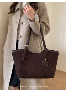 Detail of adjustable strap and matte leather texture on dark brown tote bag