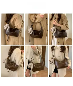 Detail showing dark brown faux leather hobo bag with plush bunny charm and pleated texture