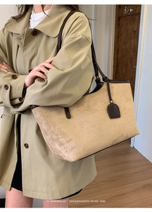 Close-up of beige suede tote bag with brown leather trim worn with a khaki trench coat