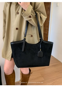 Grand sac cabas rétro en daim noir porté par un mannequin en trench-coat beige
