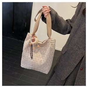 Close-up of quilted tote bag with alpaca charm and wide comfortable shoulder strap