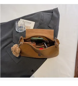 Detailansicht braune Halbmond-Umhängetasche mit Kette und süßem Bären-Charm-Anhänger
