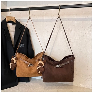 Detailed view of matte suede hobo bags featuring a turn-lock closure and bear charm