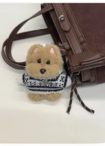 Dettaglio portachiavi a forma di cane di peluche con maglione e ciondolo inciso