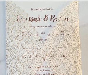 Close-up of laser-cut lace wedding invitation with intricate floral hollow pattern
