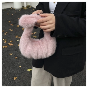 Dettaglio di una borsa a mano rosa in peluche di pelliccia sintetica con foglie d'autunno