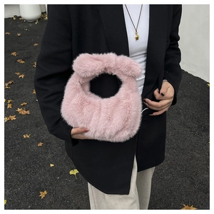 Dettaglio della texture della borsa rosa in finta pelliccia con manico morbido