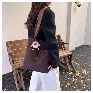 Detail of coffee quilted tote bag showing rhombus stitching and plush sheep charm