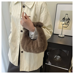 Borsa a mano chic in ecopelliccia marrone esposta in un ambiente interno minimalista